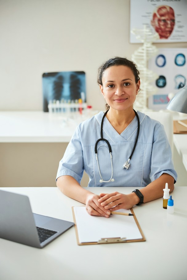 A radiologist smiling at her desk